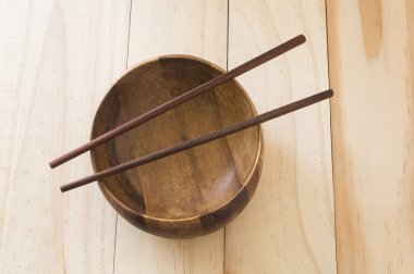 ahşap masa arka plan üzerinde çubuk ile boş kase