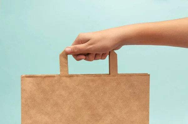 Hand Håller Papper Brun Ekologisk Väska Ljusblå Bakgrund Att Köpa — Stockfoto