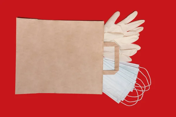 Papieren zak. De verpakking bevat witte medische beschermende handschoenen. Medische maskers. — Stockfoto