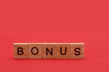 Kırmızı arkaplandaki tahta küplere yazılmış harflerden gelen ikramiye. Metin için yeri olan tasarım.