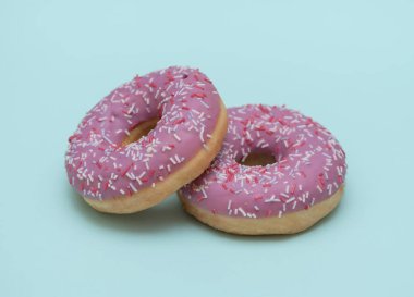 Mavi arka planda iki donut. Hamur işi. Kızarmış tatlı..