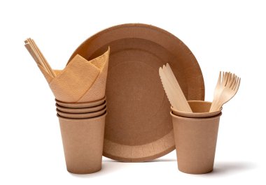 Tek kullanımlık çevre dostu sofra takımı. Kahverengi konteynırlar. Tabaklar çatallar ve bıçaklar. Beyaz bir arkaplanda.