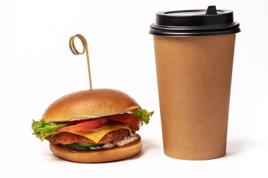 Hamburger yakın plan. Tek kullanımlık kahve fincanı. Çöreklerden, domateslerden, marullardan ve hamburgerlerden abur cubur. İzole et.