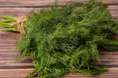 Doku olarak taze yeşil dereotu yakın plan. Yukarıdan bak. Kahverengi arka planda.