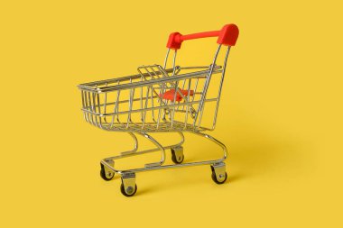 Sarı arka planda izole edilmiş boş mini alışveriş sepeti. Perakende. Satış konsepti.