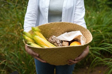 Yeşil mısır koçanı, ekmek, balkabağı ve çiçek dolu Sepetli Çiftçi Kız.