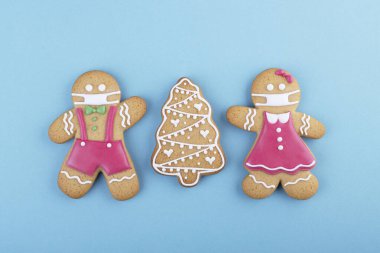 gingerbread man in a ginger cookie face mask iced sugar decoration on a blue background, minimal seasonal Pandemic Winter holiday card
