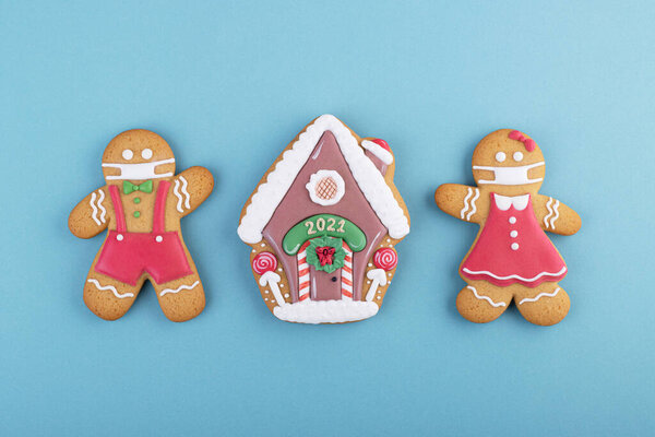 gingerbread boy and girl with a gingerbread house on a blue background. gingerbread man in the mask