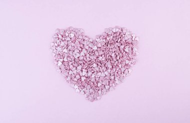 Yüzlerce küçük pembe kalp, Sevgililer Günü 'nde beyaz bir zemin üzerinde romantik aşkın sembolü olarak büyük bir kalp şeklinde yatar. Anneler Günü