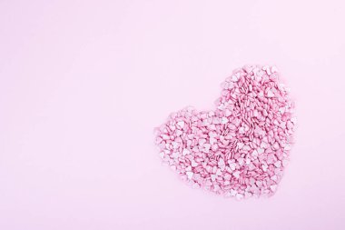 Yüzlerce küçük pembe kalp, Sevgililer Günü 'nde beyaz bir zemin üzerinde romantik aşkın sembolü olarak büyük bir kalp şeklinde yatar. Anneler Günü