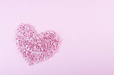 Yüzlerce küçük pembe kalp, Sevgililer Günü 'nde beyaz bir zemin üzerinde romantik aşkın sembolü olarak büyük bir kalp şeklinde yatar. Anneler Günü