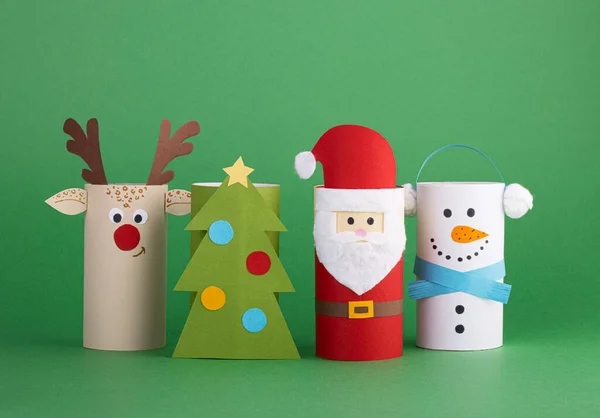 圣诞玩具从马桶管滚动的绿色背景 圣诞老人 雪人和圣诞树 新年的创意装饰 — 图库照片