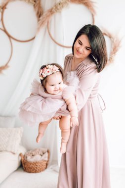 Mutlu genç anne kucağında bebeğiyle oynuyor. Mutlu aile, Anneler Günü, Aile Günü, Çocuklar Günü