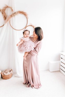 Mutlu genç anne kucağında bebeğiyle oynuyor. Mutlu aile, Anneler Günü, Aile Günü, Çocuklar Günü