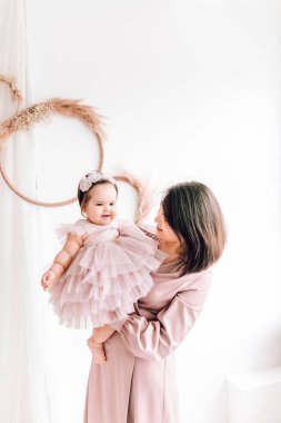 Mutlu genç anne kucağında bebeğiyle oynuyor. Mutlu aile, Anneler Günü, Aile Günü, Çocuklar Günü