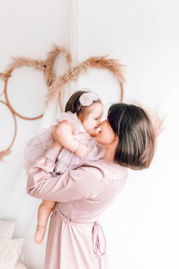 Mutlu genç anne kucağında bebeğiyle oynuyor. Mutlu aile, Anneler Günü, Aile Günü, Çocuklar Günü