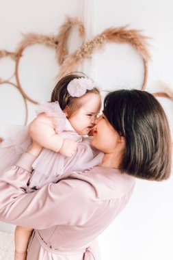 Mutlu genç anne kucağında bebeğiyle oynuyor. Mutlu aile, Anneler Günü, Aile Günü, Çocuklar Günü