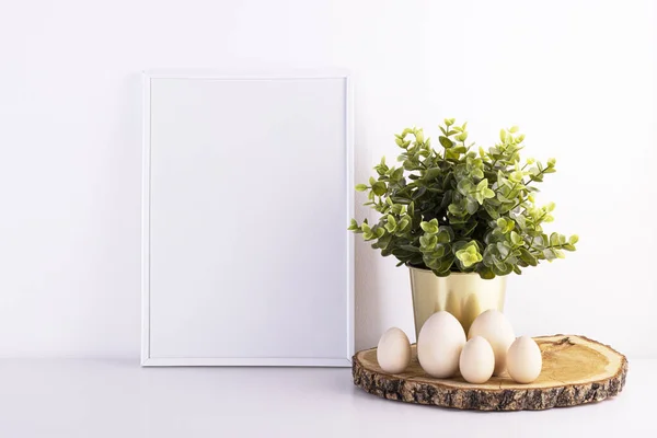 Blank white text frame with Easter eggs on a white table. the interior is minimalism. orthodox holiday Easter