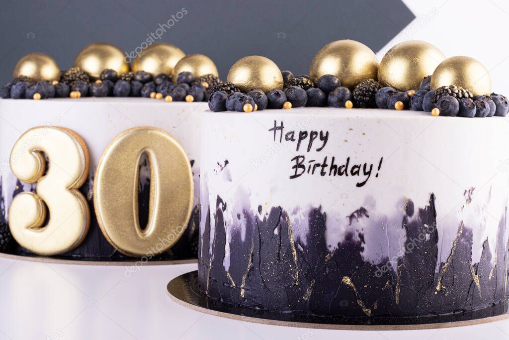 Festive black and white cakes 30 years old with golden balls and dark berries. birthday and anniversary cake