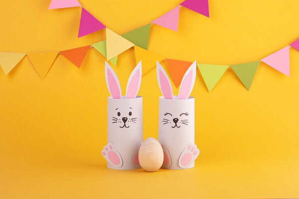Cute Easter bunnies made of paper with Easter eggs, handmade. Happy Easter. Spring Festival