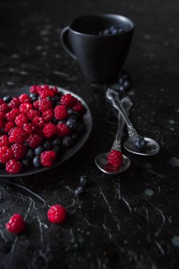 Ahududu ve yabanmersini, siyah arka planda, yabanmersini