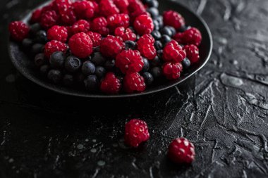 Ahududu ve yabanmersini, siyah arka planda, yabanmersini