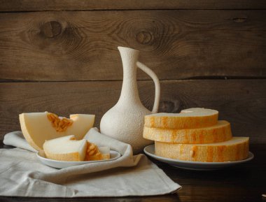 Masada kavun dilimleri, sürahi, ahşap zemin