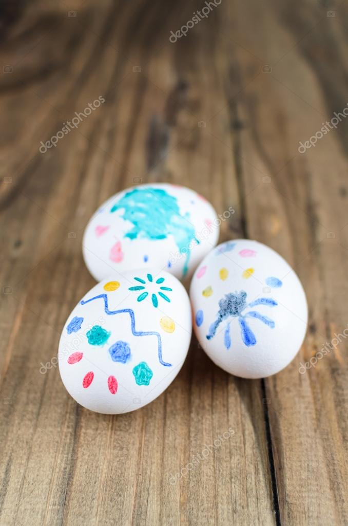 Homemade painted easter eggs over wooden rustic background