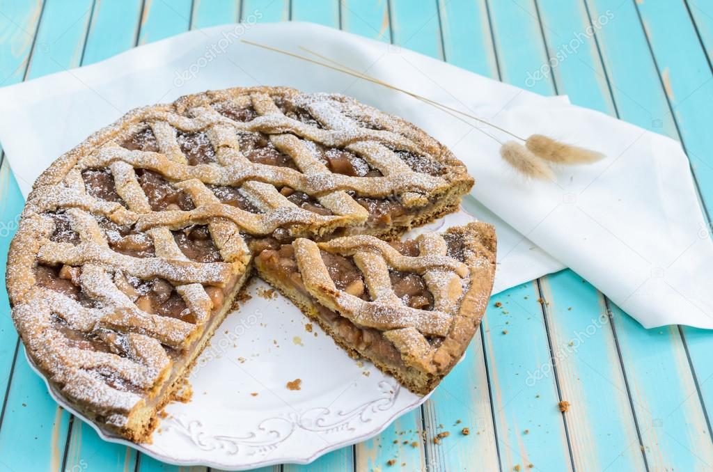 Homemade rustic apple tart pie on dish over wooden turquoise background