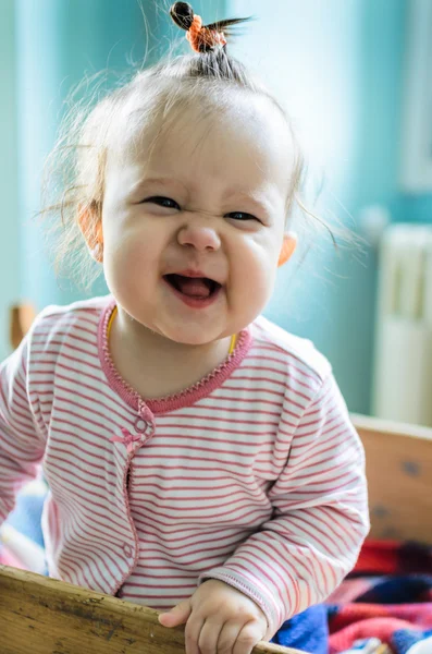 Portrait of adorable little smiling baby girl staying at her bed — Stock Photo, Image