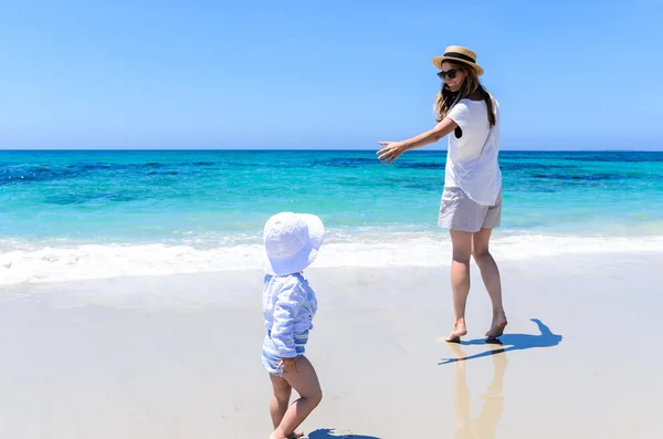 Jovem mãe adorável se divertindo com a filha na praia tropical — Fotografia de Stock