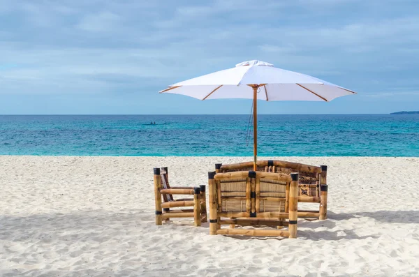 Vue station tropicale avec table de plage, chaises et parasol sur plage de sable exotique — Photo