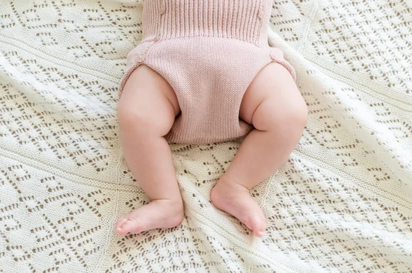 Pequenos pés de bebê recém-nascido em shorts de lã — Fotografia de Stock