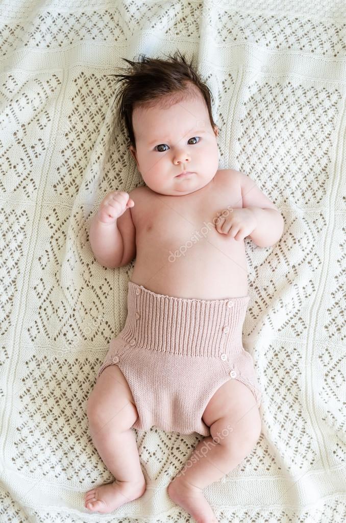 Beautiful newborn baby girl lying on woolen blanket