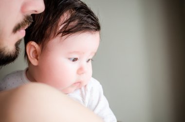 Portrait of happy beautiful little baby girl sitting oh father's hands
