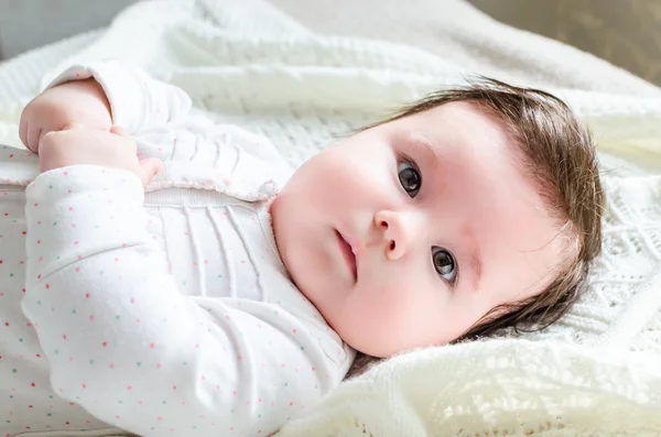 Cute newborn baby girl in romper suit lying on woolen blanket — Stock Photo, Image