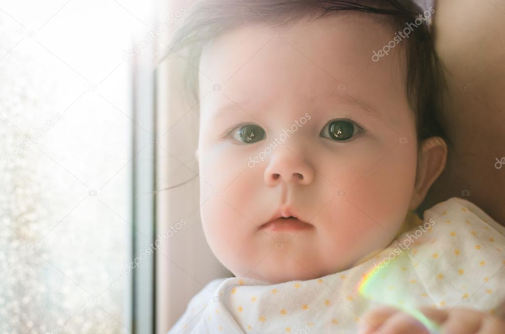 Portrait of cute caucasian little baby girl in backlight