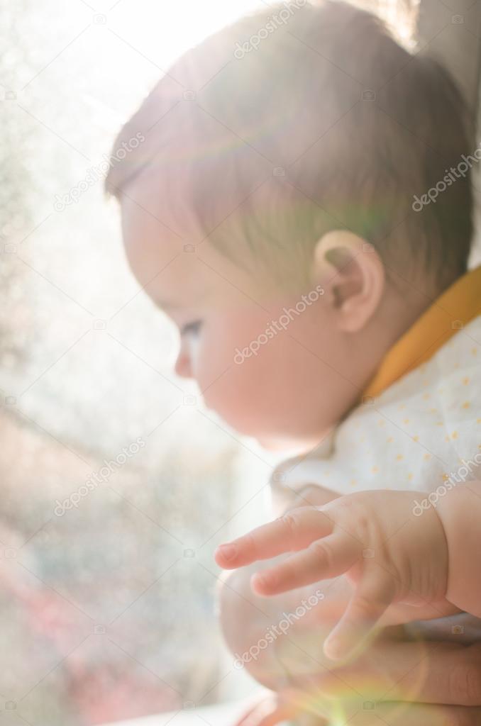 Portrait of cute caucasian little baby girl in backlight