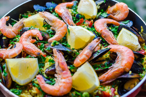 Close up classic seafood paella with mussels, shrimps and vegetables