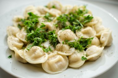 Boiled russian dumplings on the plate with parsley
