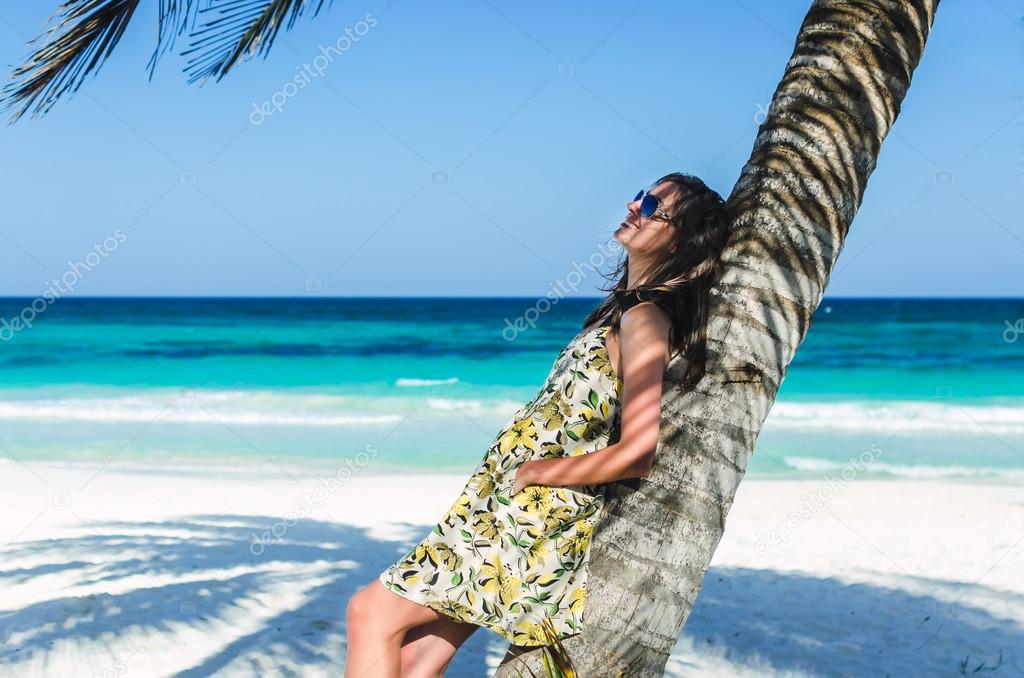 Young adorable woman at tropical sandy beach during Caribbean vacation