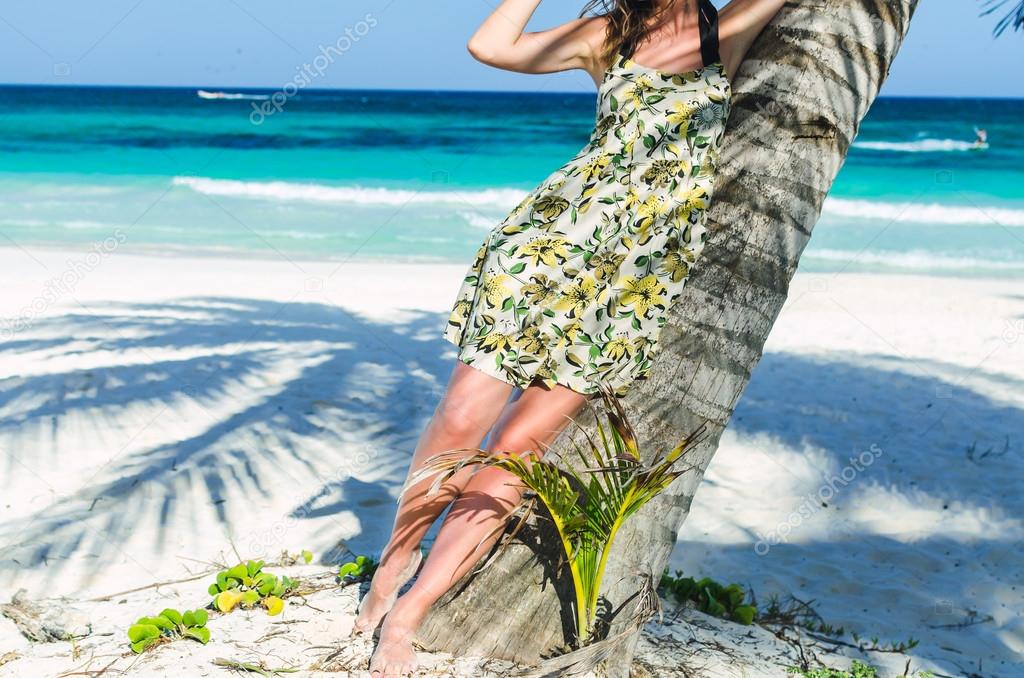 Young adorable woman at tropical sandy beach during Caribbean vacation