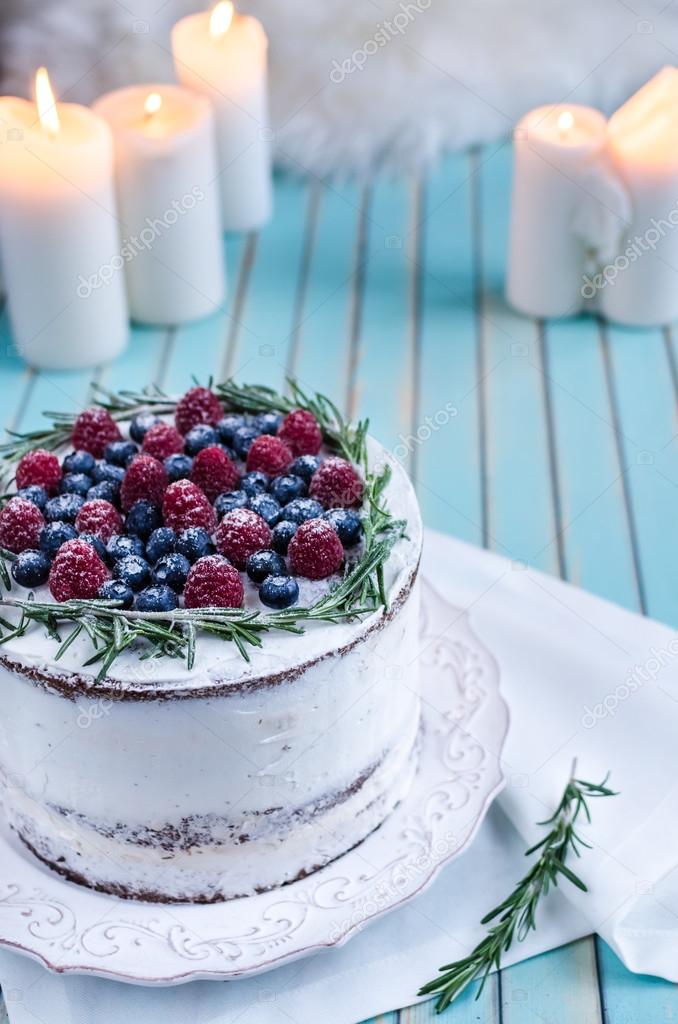 Homemade cake decorated berries on plate over wooden turquoise background