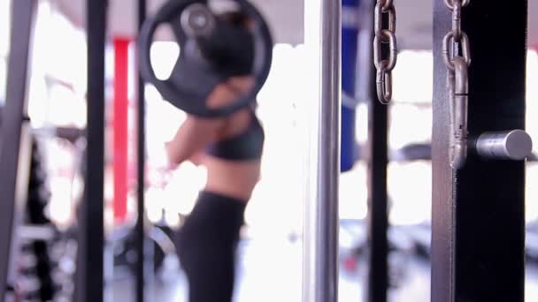 离焦模糊的女人完成杠铃深蹲练习，在健身房训练的女运动员 — 图库视频影像