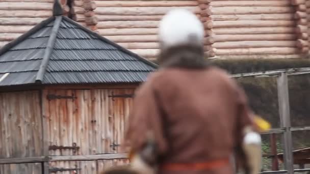 Человек в средневековом костюме покидает поле боя, рыцарь выигрывает турнир по борьбе на мечах — стоковое видео