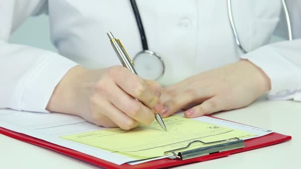 Primer plano de las manos de la doctora que escribe la prescripción y se la da al paciente — Vídeo de stock