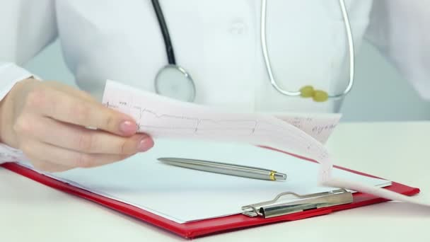 Cardiologue étudiant l'électrocardiogramme, analysant les symptômes, faisant un diagnostic — Video