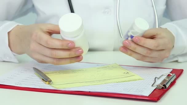 Крупним планом руки лікаря пишуть рецепт, призначаючи ліки пацієнта — стокове відео