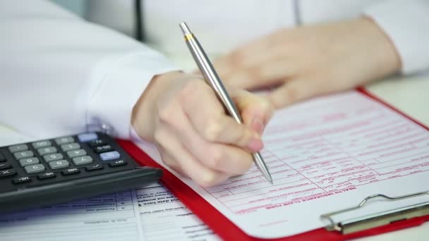 Gros plan des mains du médecin remplir le formulaire de demande d'assurance maladie, vérifier les coûts — Video