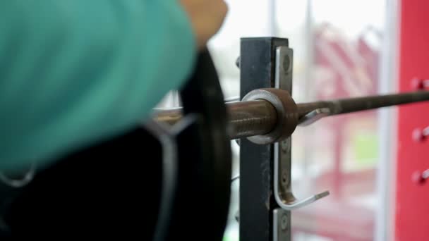 Atleta masculino que se prepara para el entrenamiento intensivo, cargando placas pesadas en la barra — Vídeos de Stock